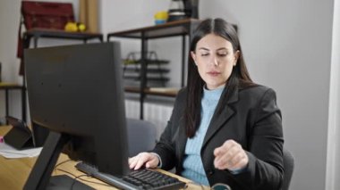 Ofiste ekranı görme sorunu olan genç İspanyol kadın iş kadını.