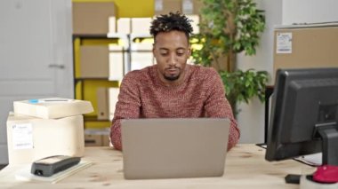 Afrika kökenli Amerikalı iş adamı. Ofiste birinci sınıf jest yapan bir dizüstü bilgisayar kullanıyor.