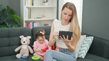 Anne ve kızı evde çember oynarken dokunmatik ped kullanıyorlar.