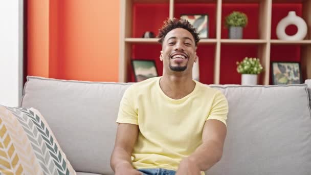 Afrikanischer Mann Lächelt Selbstbewusst Auf Sofa Und Spricht Hause — Stockvideo
