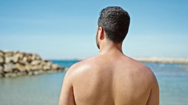 Jonge Spaanse Man Toerist Staat Shirtloos Achterstevoren Het Strand — Stockvideo
