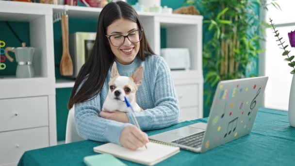 Wanita Hispanik Muda Dengan Anjing Chihuahua Menggunakan Laptop Menulis Catatan — Stok Video