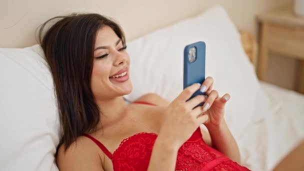 年轻的高加索女人穿着紧身衣 在卧室里用智能手机 — 图库视频影像