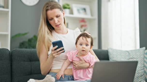 Μητέρα Και Κόρη Κάθονται Στον Καναπέ Χρησιμοποιώντας Smartphone Και Laptop — Αρχείο Βίντεο