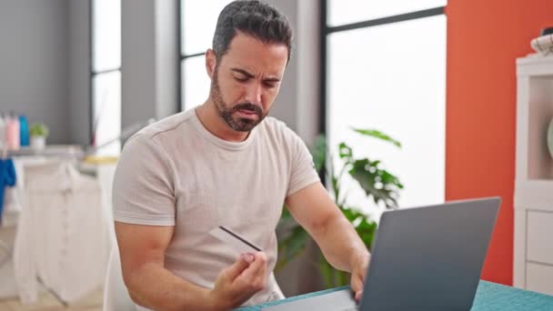 Young Hispanic Man Using Laptop Holding Credit Card Looking Upset — Stock Video