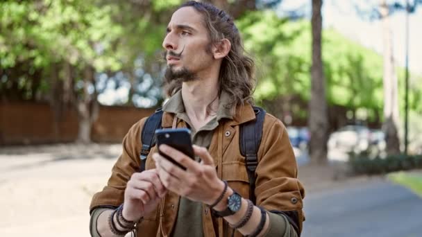 Νεαρός Ισπανόφωνος Τουρίστας Χρησιμοποιώντας Smartphone Στο Πάρκο — Αρχείο Βίντεο