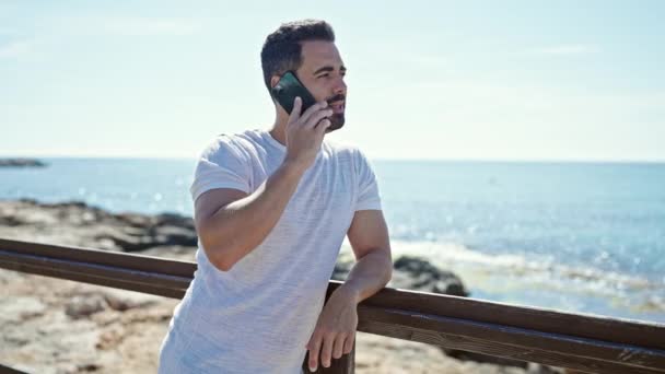 Ung Latinamerikansk Man Ler Säker Talar Smartphone Vid Havet — Stockvideo
