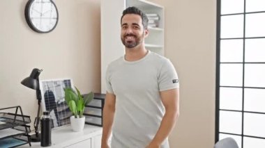Genç İspanyol iş adamı ofis kamerasına bakıyor.