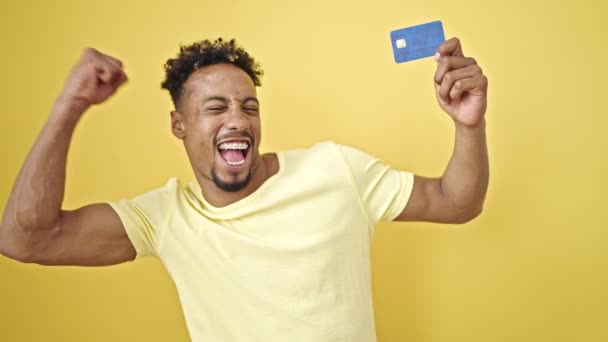 Africký Američan Držící Kreditní Kartu Vítězným Gestem Nad Izolované Žluté — Stock video