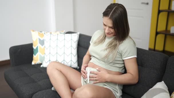 Young Pregnant Woman Smiling Confident Touching Belly Home — Stok video