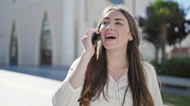 Young beautiful hispanic woman smiling confident talking on smartphone at street