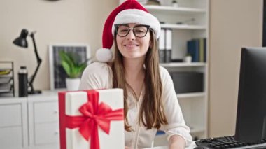 Genç ve güzel İspanyol iş kadını ofiste Noel 'i kutlayan bir bilgisayar kullanıyor.