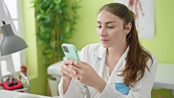 Young Beautiful Hispanic Woman Doctor Using Smartphone Working Clinic — Stock video