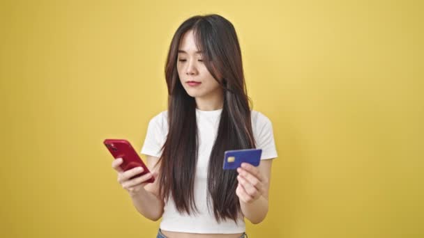 Молодая Китаянка Делает Покупки Смартфоном Кредитной Картой Изолированном Желтом Фоне — стоковое видео