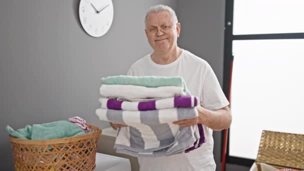 Středního Věku Šedovlasý Muž Úsměvem Sebevědomě Drží Složené Ručníky Prádelně — Stock video