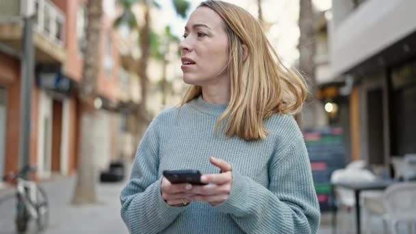 Jeune Femme Blonde Utilisant Smartphone Avec Une Expression Sérieuse Rue — Video