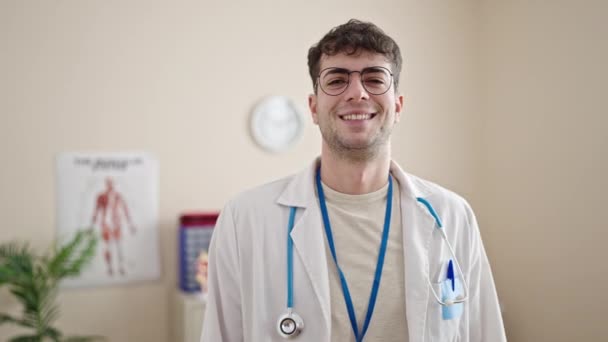 Młody Latynos Człowiek Lekarz Uśmiecha Pewny Siebie Stojąc Klinice — Wideo stockowe