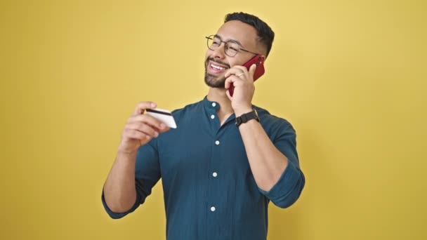 Jonge Latijns Amerikaanse Man Aan Telefoon Met Creditcard Geïsoleerde Gele — Stockvideo