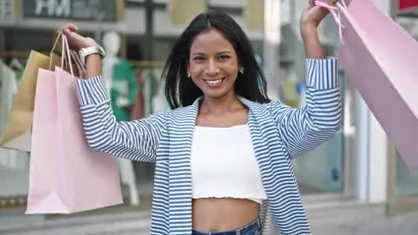 アフリカ系アメリカ人女性が路上で袋を持って買い物に行く笑顔 — ストック動画