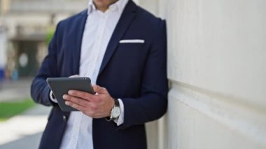 Sokakta dokunmatik ped kullanan genç Latin iş adamı.