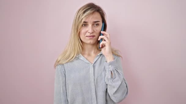 Νεαρή Ξανθιά Γυναίκα Που Μιλάει Στο Smartphone Σοβαρή Έκφραση Απομονωμένο — Αρχείο Βίντεο