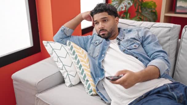 Hombre Afroamericano Viendo Televisión Acostado Sofá Con Expresión Aburrida Casa — Vídeos de Stock