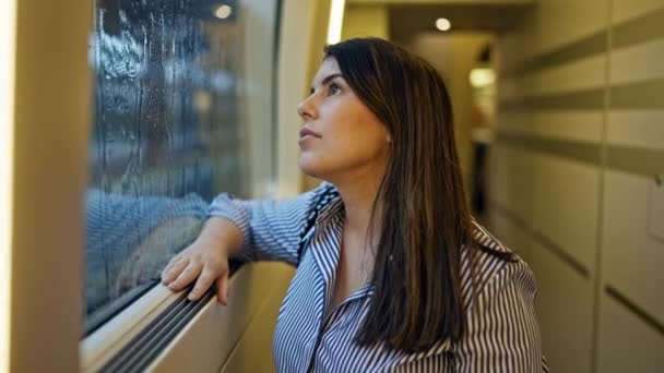 年轻美丽的惊慌失措的女人看着窗外 外面的火车车厢里下着雨 — 图库视频影像