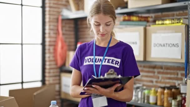 Joven Mujer Rubia Voluntaria Escribiendo Portapapeles Chequeando Centro Caridad — Vídeos de Stock