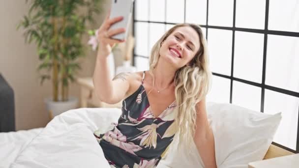 Νεαρή Ξανθιά Γυναίκα Κάνει Selfie Από Smartphone Κάθεται Στο Κρεβάτι — Αρχείο Βίντεο