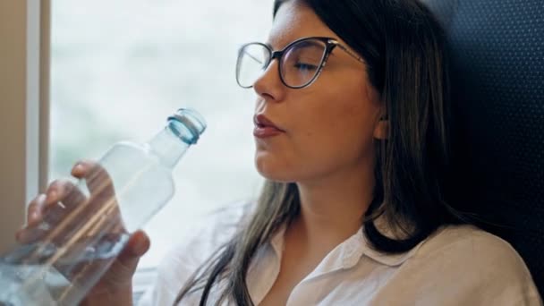 火车站的年轻美丽的惊慌失措的女人正在用塑料瓶喝水 — 图库视频影像