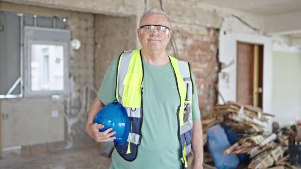 Grauhaariger Bauarbeiter Mittleren Alters Lächelt Selbstbewusst Und Hält Seinen Hut — Stockvideo