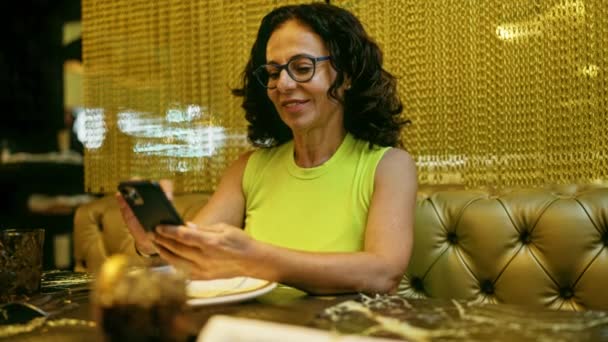 Μεσήλικη Ισπανόφωνη Γυναίκα Που Χρησιμοποιεί Smartphone Εστιατόριο — Αρχείο Βίντεο