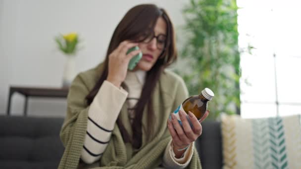 年轻美丽的惊慌失措的女人拿着药瓶在家里进行医疗电话咨询 — 图库视频影像