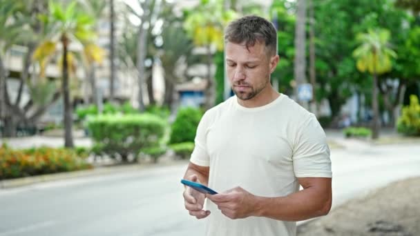 Hombre Joven Hablando Teléfono Inteligente Con Expresión Seria Alejándose Parque — Vídeo de stock