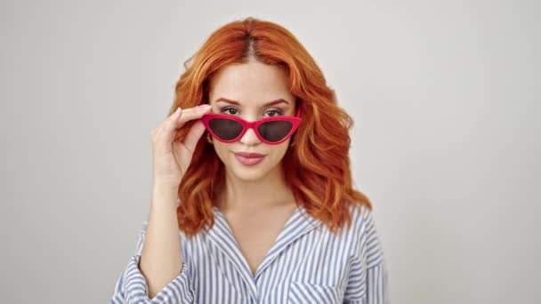 Młoda Ruda Kobieta Nosi Okulary Przeciwsłoneczne Dmuchanie Pocałunek Odizolowanym Białym — Wideo stockowe