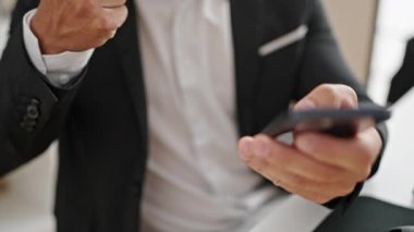 Young man business worker using smartphone drinking coffee at office