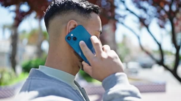 公園で電話で話す若いヒスパニック系の男 — ストック動画