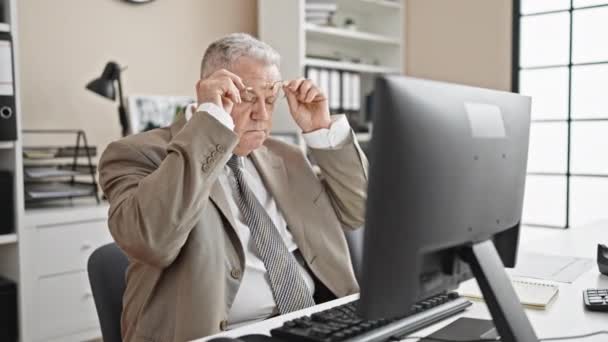 中年白发苍苍的生意人厌倦了在办公室用电脑拿眼镜 — 图库视频影像