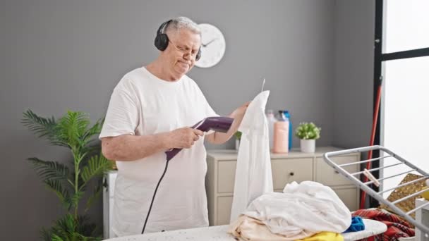 Hombre Pelo Gris Mediana Edad Escuchando Música Planchando Camisa Lavandería — Vídeos de Stock