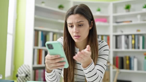 Jovem Bela Estudante Hispânica Usando Smartphone Olhando Chateado Universidade Biblioteca — Vídeo de Stock