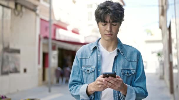 Jovem Hispânico Usando Smartphone Com Expressão Séria Rua — Vídeo de Stock