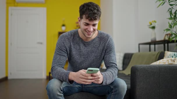 Young Hispanic Man Using Smartphone Smiling Sitting Sofa Home — Stock Video