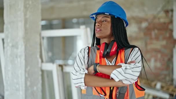 在建筑工地 非洲裔美国女建筑工人自信地站在那里 双手交叉地微笑着 — 图库视频影像