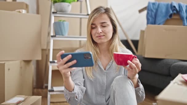 Jovem Loira Usando Smartphone Beber Café Nova Casa — Vídeo de Stock