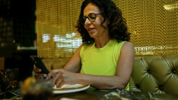 在餐馆用智能手机的中年惊慌失措女人 — 图库视频影像