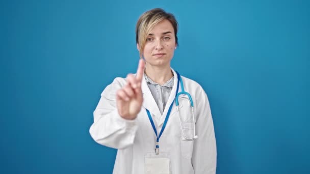 Fiatal Szőke Orvos Áll Komoly Arckifejezéssel Nemet Mond Ujjával Izolált — Stock videók