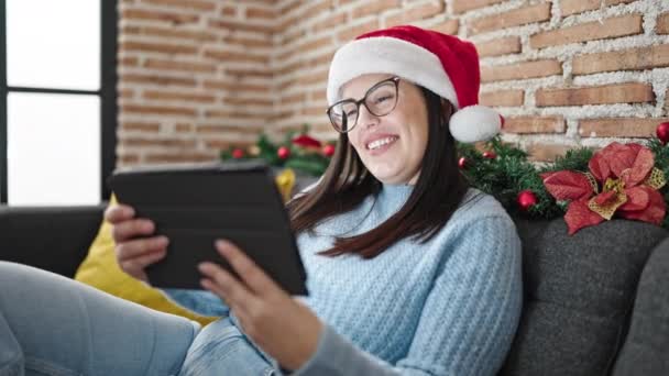 Young Hispanic Woman Using Touchpad Sitting Sofa Wearing Christmas Hat — Stock Video