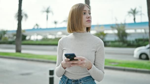 Mujer Rubia Joven Usando Smartphone Con Expresión Seria Calle — Vídeos de Stock