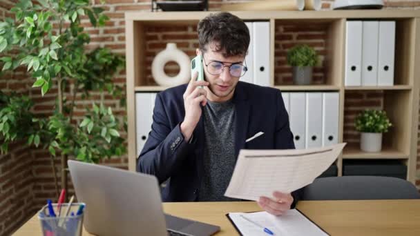 Молодий Іспаномовний Чоловік Бізнесмен Розмовляє Телефону Читаючи Документ Офісі — стокове відео