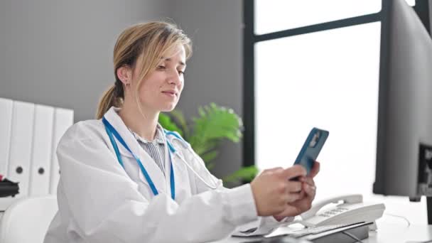 Joven Doctora Rubia Usando Smartphone Trabajando Clínica — Vídeos de Stock